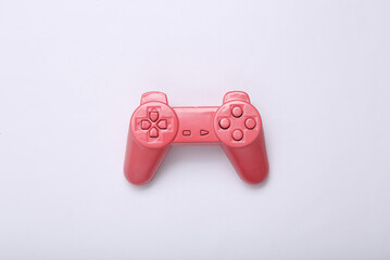 Creative gaming layout. Pink retro gamepad on white background. Minimalism. Concept art. Modern still life. Flat lay. Top view.