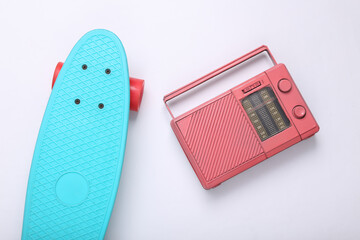 Pink radio receiver and penny board on white background. Creative hipster layout. Minimal concept....