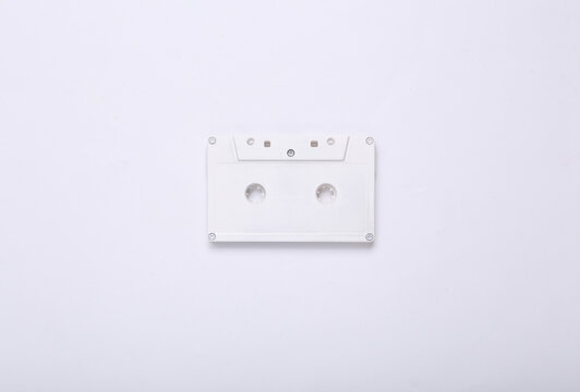 Creative music layout. White retro audio cassette on white background. Minimalism. Concept art. Modern still life. Flat lay. Top view.