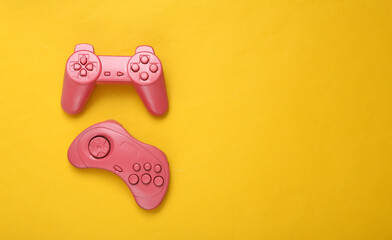 Creative gaming layout. Retro gamepads on yellow background. Minimalism. Concept art. Copy space. Flat lay. Top view.