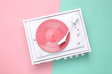Turntable vinyl record player on pink blue background. Sound technology for DJ to mix and play...