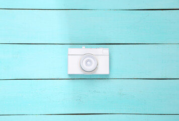 White retro camera on blue wooden background. Creative minimalism layout. Top view. Flat lay