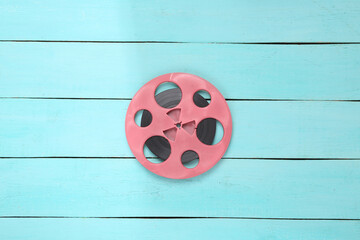 Music layout. Pink audio reel on blue wooden background. Top view. Flat lay
