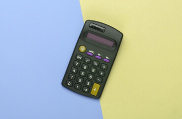 Black calculator on yellow blue background. Top view