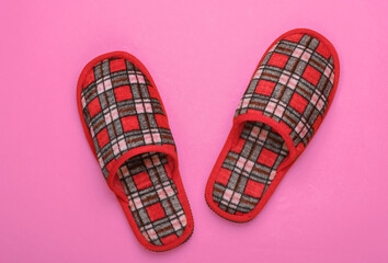Checkered indoor slippers on a pink background. Top view