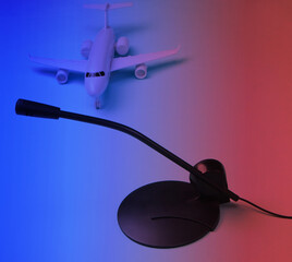 Air traffic controller, flight dispatcher. Plane figurine, microphone in neon light