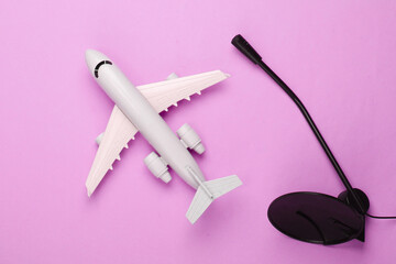 Air traffic controller, flight dispatcher. Plane figurine, microphone on pink background