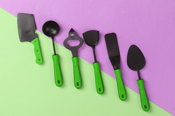 Toy kitchen tools on a pink-green pastel background. Top view