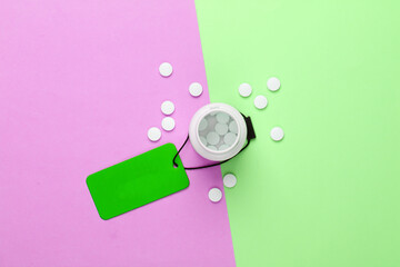 Pills bottle with green sale tag. Top view. Discount. Minimalism