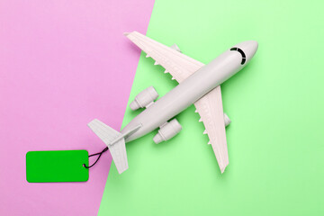 Airplane figurine with green sale tag. Top view. Discount. Minimalism