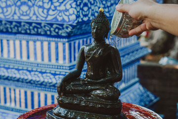 Thai people celebrate Songkran Festival by pouring water over 
Buddha statue to signify cleansing...