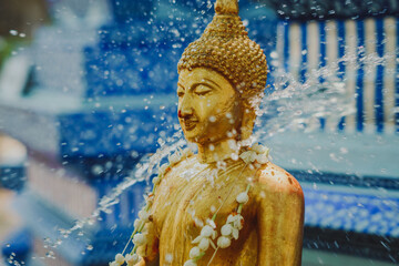 Thai people celebrate Songkran Festival by pouring water over 
Buddha statue to signify cleansing...