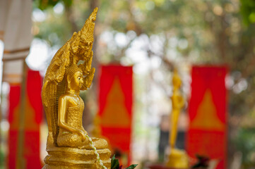 Thai people celebrate Songkran Festival by pouring water over 
Buddha statue to signify cleansing...