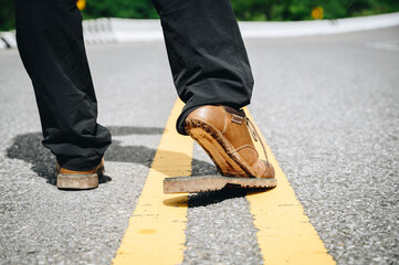 Cropped shot of man walking on the road while wearing torn broken shoes. Close-up of broken leather shoes need to repair.