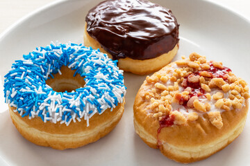 Three different donuts on white plate.