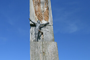 Stara figurka Jezusa na zniszczonym krzyżu.