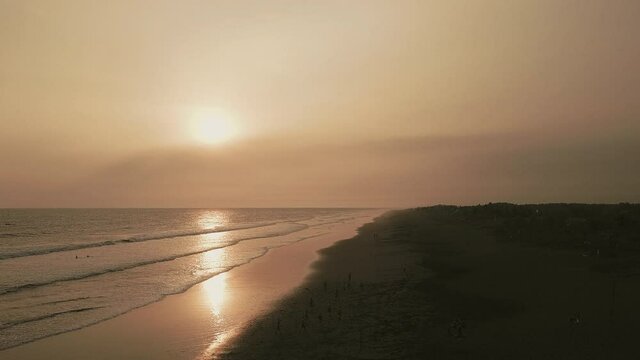 Aerial view of Guatemalan people playing soccer on El Paredon Beach at sunset