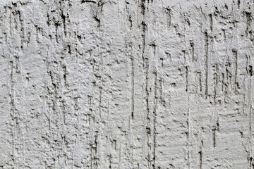 Gray concrete wall with uneven rough plaster