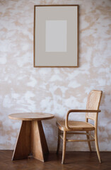 Vertical view. rattan chair and old wooden table with picture fram on the wall in living room, Vintage style