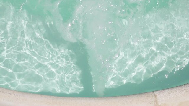 Water bubbles bursting on the jacuzzi section of the pool, view from the top