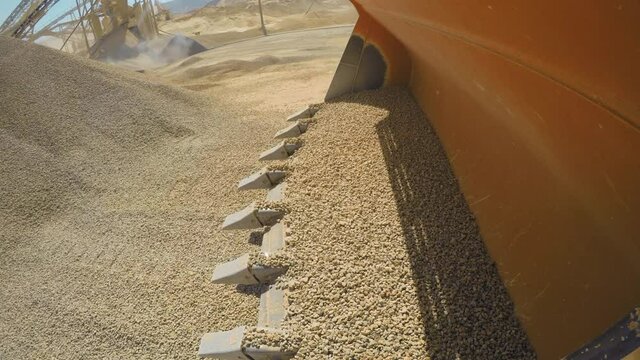 Industrial sand mining. Very Interesting Point of View. 4K Camera is Stuck on a working loader. Left side. Loading and dumping gravels into a truck, Industrial machinery at sand quarry, 4K footage.