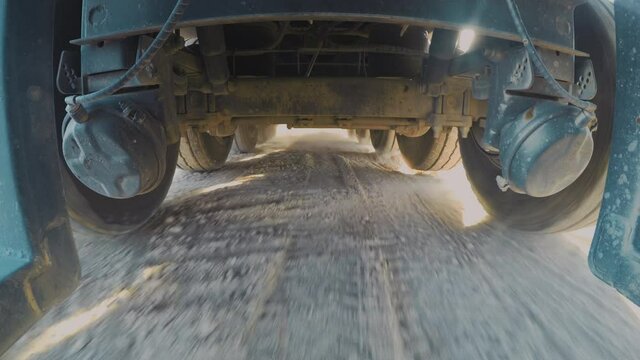 Industrial machinery. Truck driving on Sand Terrain. 4K camera is under a truck while driving on a hard sand terrain, Interesting point of view. Truck 4x4 Drive. 4k footage