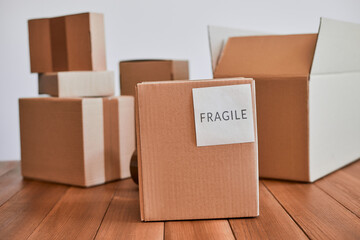 Cardboard box with fragile label on wooden desk