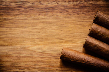 Group of brown cuban cigars on wooden background