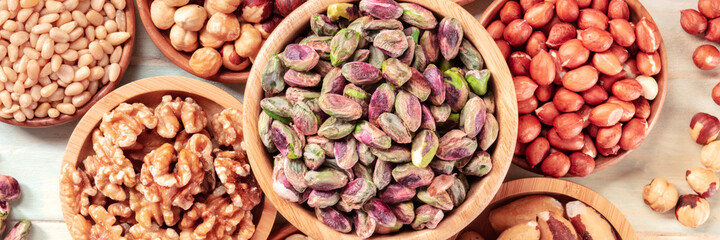 Nuts panorama, overhead flat lay shot. Pistachios, walnuts, peanuts etc