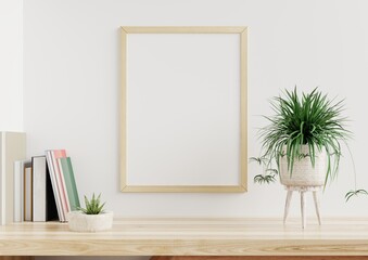 Photo frame mockup on a white wall in the living room, a flower pot and paper placed on a wooden table.3d rendering.