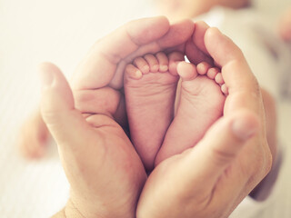 Selective focus close up a feet of newborn baby in parent 's hand , Parental care and happy family concept