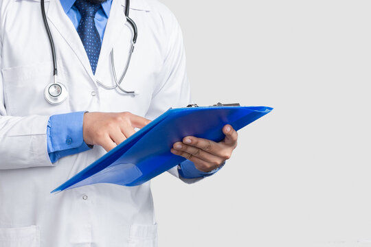 Doctor In Lab Coat Holding And Reading Patient File Or Medical Notes Looking, Isolated On White Background