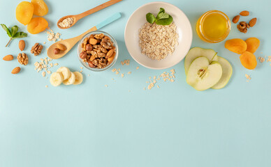 Ingredients for making breakfast with granola and fruits on blue background top view, flat lay....