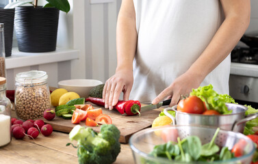 Fototapeta na wymiar Healthy lifestyle and wholesome food concept. Pregnant women in early pregnancy preparing a healthy breakfast or dinner from fresh vegetables in the home kitchen