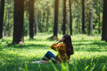 A young woman enjoy listening to music with headphone with feeling happy and relaxed in the park
