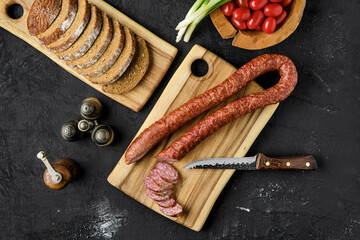 Overhead view of smoked pork sausage rings on wooden cutting board
