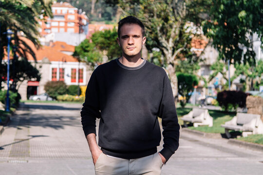 portrait of young man walking in the park on the walk