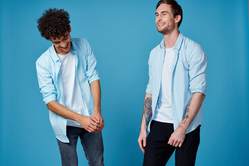 friends in unbuttoned shirts and white t-shirts jeans blue background fun communication party