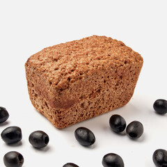 small rye bread on a white plate with olives