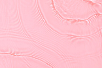 de-focused. Closeup of pink transparent clear calm water surface texture with splashes and bubbles. Trendy abstract summer nature background. Coral colored waves in sunlight. Copy space