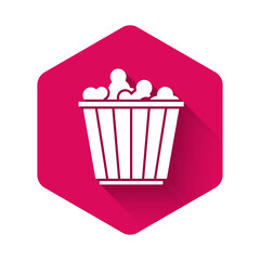 White Popcorn in cardboard box icon isolated with long shadow. Popcorn bucket box. Pink hexagon button. Vector