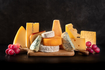 Cheese and grapes, a still life on a black background