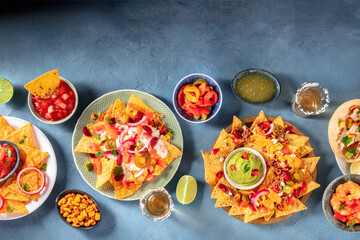 Mexican food on a table. Nachos, dips, ceviche, tequila and other dishes