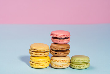 French dessert macaron on pink and blue background. Modern Macarons on colorful background. copy space.
