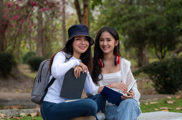 Shot of two Asian college student or University look at the camera at park