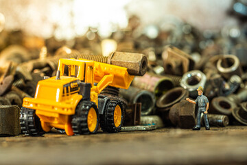 Yellow toy dump truck and typewriter tractor bulldozer with pile of old screws nuts and bolts © Werachat