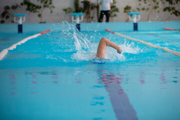 An athlete is swimming in the sports pool.