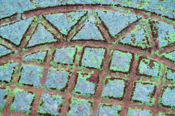 The texture of a fragment of a sewer manhole close up painted once upon a time with swamp color paint