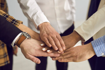 Group of people putting hands together. Diverse business team joining hands in corporate meeting feeling united and confident about company's future. Success and teamwork concept, human hands up close