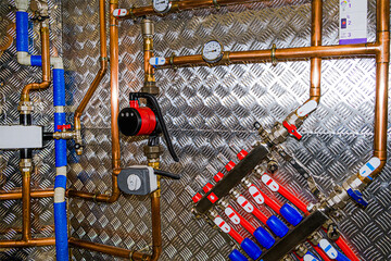 Fototapeta na wymiar Plumbing services. Stainless steel piping of the heating system in the boiler room. Heating thermoregulation system. Pump and sensors.